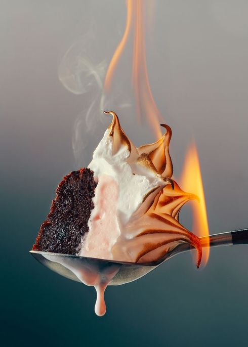 A flaming dessert held on a spoon